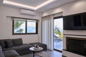 a living room with a couch and a fireplace at Villa Rock&SeaView in Livanates