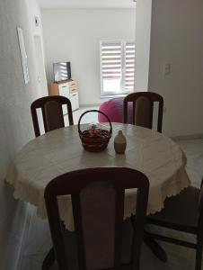 a dining room table with a basket on top of it at Apartman Ema in Bihać +11 photos