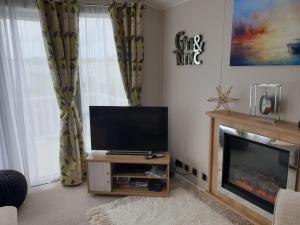 a living room with a flat screen tv and a fireplace at K7 Annandale in Winthorpe