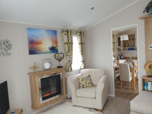 a living room with a fireplace and a chair at K7 Annandale in Winthorpe