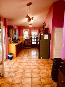 a kitchen with red walls and a green refrigerator at Rancho Colibrí in Acajutla