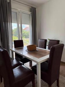 a dining room table and chairs with a window at Cerak lux in Bele Vode
