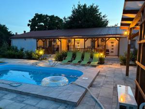 a patio with a pool and chairs and a house at Samu Tanya in Gyula