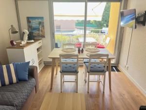 a living room with a table and chairs and a couch at appartement T2 climatisé proche centre et plage in Cavalaire-sur-Mer +18 photos