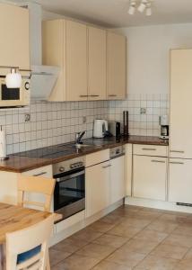 a kitchen with white cabinets and a table in it at Ferienwohnung Salvenblick in Söll