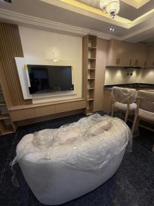 a room with a large bed and a flat screen tv at The Pointe Apartments in Agege