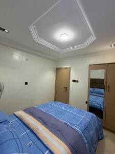 a bedroom with a bed with a blue comforter at The Pointe Apartments in Agege