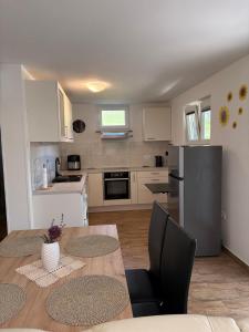 a kitchen with a table and a kitchen with a refrigerator at Apartma Zari in Marezige