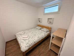 a small bedroom with a bed and a table at Apartma Zari in Marezige