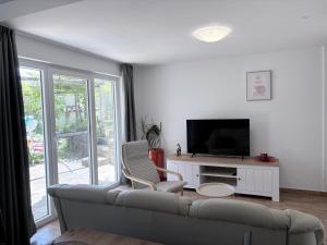 a living room with a couch and a television at Apartma Zari in Marezige