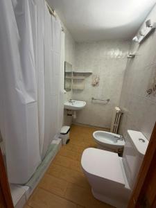 a white bathroom with a toilet and a sink at Miramar Viladecans in Viladecáns +50 photos