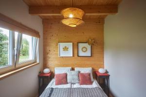 a bedroom with a bed with a wooden wall at Kwiatowisko in Szewnia