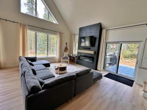 a large living room with a couch and a tv at Quiet detached home steps from all the action! in Panorama