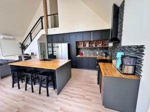 a kitchen with black cabinets and a wooden counter top at Quiet detached home steps from all the action! in Panorama