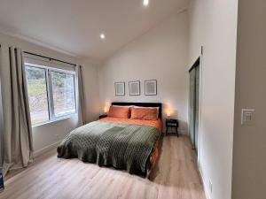 a bedroom with a bed with orange pillows and a window at Quiet detached home steps from all the action! in Panorama +31 photos