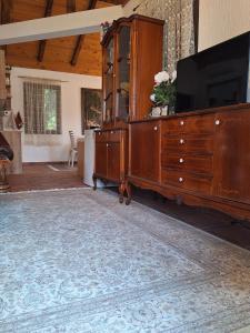a living room with a tv and a wooden dresser at Small house in Danilovgrad +22 photos