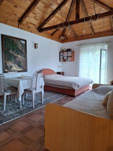 a bedroom with a bed and a table and chairs at Small house in Danilovgrad