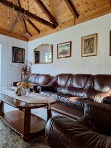 a living room with a leather couch and a table at Small house in Danilovgrad