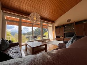 a living room with a couch and a large window at Waldhaus Max in Bad Wildbad