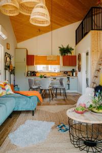 a living room with a blue couch and a kitchen at Kwiatowisko in Szewnia