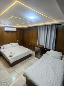 ein Schlafzimmer mit zwei Betten und einem Fernseher in der Unterkunft Dell Celio Hotel in Kairo