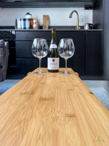 two wine glasses sitting on a wooden table at Urban Waves 1 in Netanya
