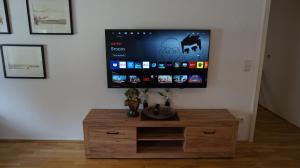 a flat screen tv on a wall with a wooden cabinet at Casa di Traditionale im Herzen von Bad Aibling Tradition trifft auf moderne Gemütlichkeit auf 138qm in Bad Aibling