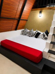 a bedroom with a bed with a red blanket at Pahana village Sigiriya in Sigiriya