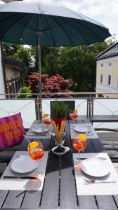 a picnic table with a green umbrella on a balcony at Casa di Traditionale im Herzen von Bad Aibling Tradition trifft auf moderne Gemütlichkeit auf 138qm in Bad Aibling