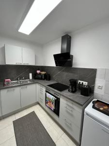 a kitchen with a sink and a stove top oven at Ferienwohnung Tor zum Oberwald in Herbstein +4 photos