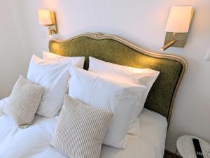 a bed with white pillows and two lamps on the wall at VILLA climatisée - 4 étoiles - 75 m2 avec Jardin pour 3 personnes - à 10 min de Besançon in Dannemarie-sur-Crête