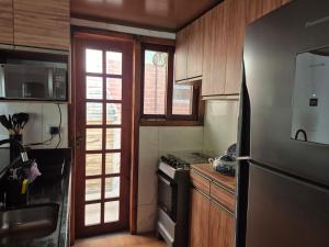 a kitchen with a refrigerator and a stove at Privê Monte Serrat, Chalé 18 in Gravatá