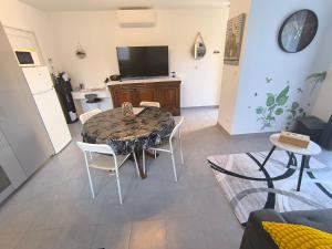 a living room with a table and chairs and a television at Une pause à Magny appartement de 51 m2 proche Beaune et Dijon NETFLIX gratuit in Magny-lès-Villers