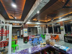 a large room with colorful chairs and a table at Amigo's Hotel and Restaurant in Nandaprayāg
