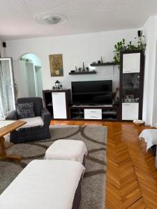 a living room with a couch and a television at Cerak lux in Bele Vode