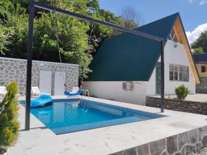 a swimming pool with a swing in a yard at Ismayilli in İsmayıllı