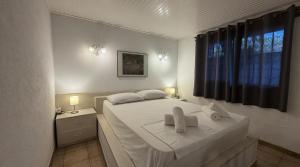 a bedroom with a white bed with two towels on it at The House On The Beach in Paleo Tsifliki +27 photos