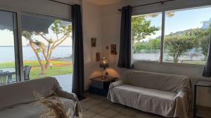 a living room with a couch and a view of the ocean at The House On The Beach in Paleo Tsifliki