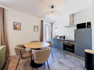 a kitchen with a table and chairs in a kitchen at L'Arrière Cour in Montbéliard +7 photos