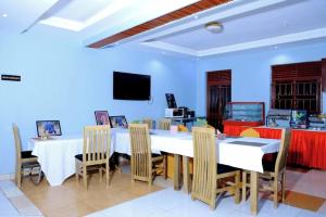 a dining room with a table and chairs and a tv at BUDDIEZ hotel limited in Kampala