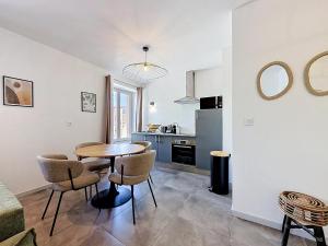 a kitchen and dining room with a table and chairs at L'Arrière Cour in Montbéliard