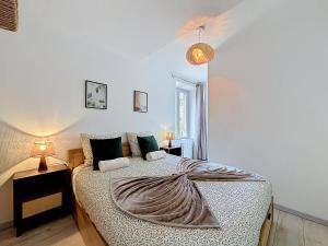 a bedroom with a bed with a blanket on it at L'Arrière Cour in Montbéliard
