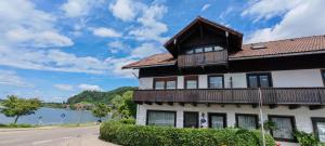a building on the side of a road next to a lake at Direkt am Hopfensee- große Ferienwohnung in Füssen +31 photos