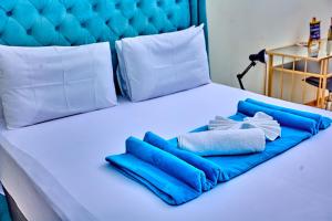 a bed with blue and white towels on it at Potato Suites n Spa in Gaborone