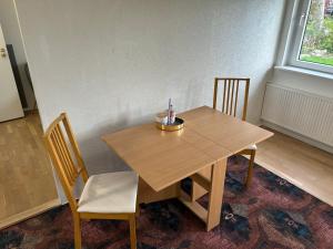 a wooden table with two chairs and a candle on it at FLC 11 Rooms in Rødby