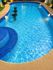 a large blue swimming pool with a fountain in it at Affordable pool villa in premium location in Pattaya