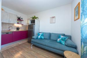 a living room with a blue couch in a kitchen at Villa Vineyard oaza in Brela