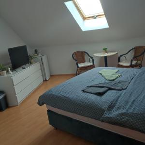 a bedroom with a bed and a tv and chairs at Međimurski San in Lopatinec