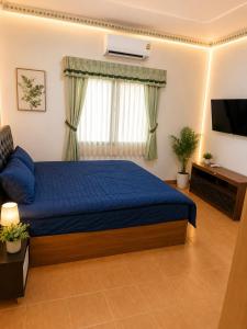 a bedroom with a blue bed and a television at Affordable pool villa in premium location in Pattaya