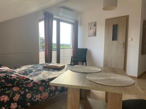 a bedroom with a bed and a table and a window at Gregorek in Ostrowo